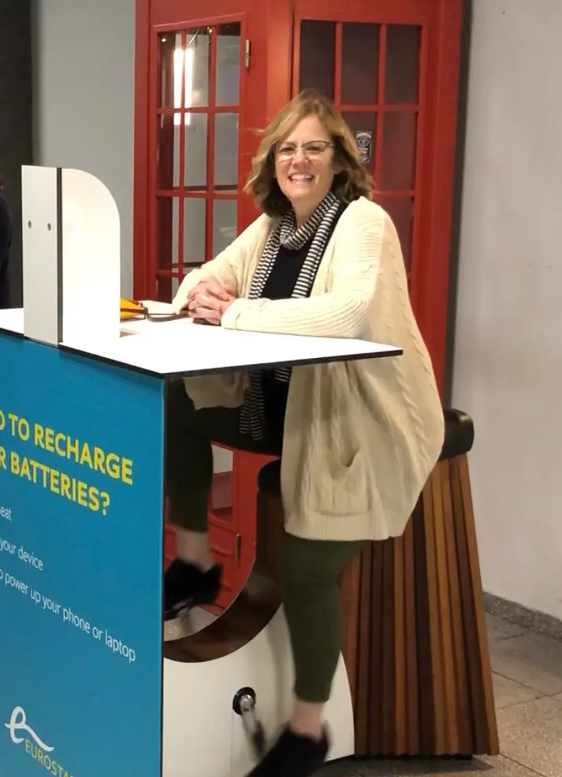 Denise riding the bike to charge her devices.