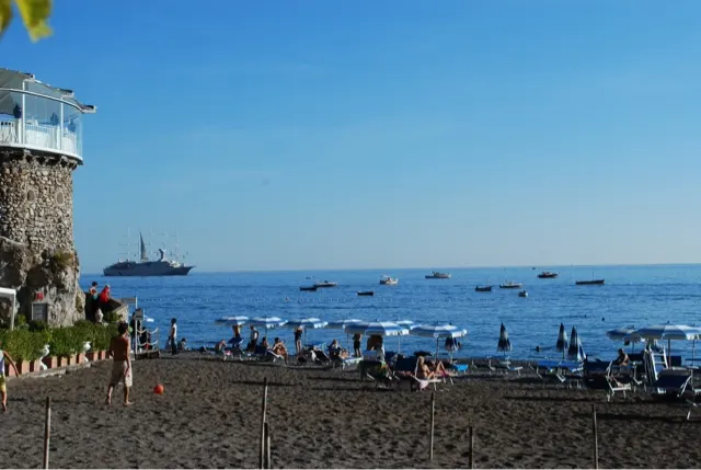 Small portion of the beach with a small cruise ship in the bay...