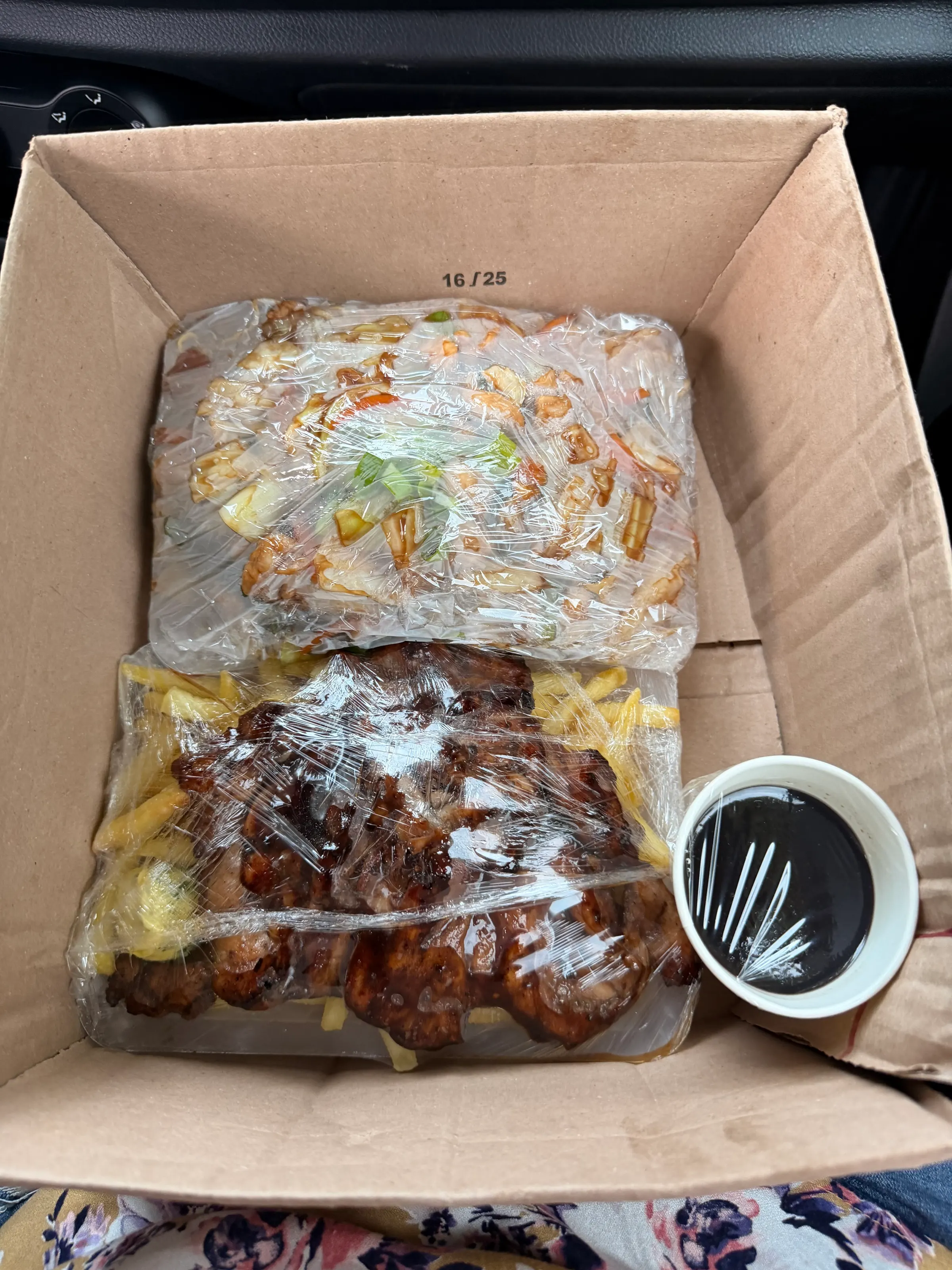 You can see the packaging of our food. Chow mein at the top and BBQ chicken and fries at the lower half with some BBQ sauce in a cup. Really good stuff. Huge portion size.