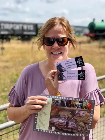 Happy coal miner's daughter with tickets to go into the hole...