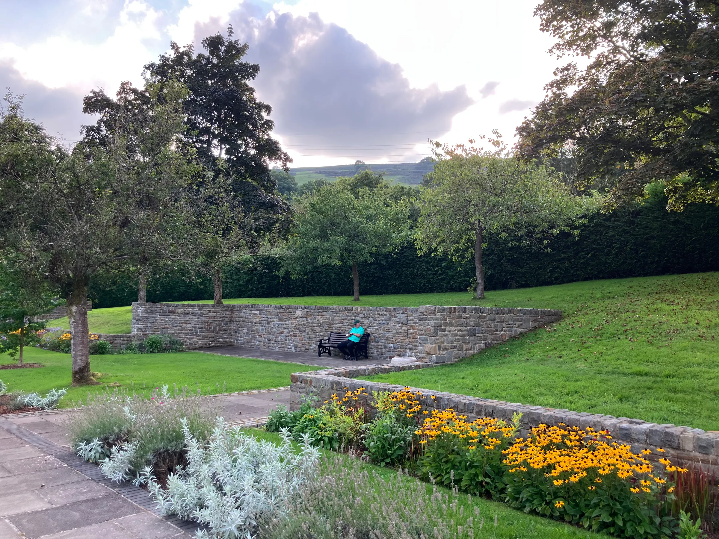 Pat and Lisa had the opportunity to use Zoom to watch their daughter speak in church back in America. They did that while sitting on this bench in this memorial garden.