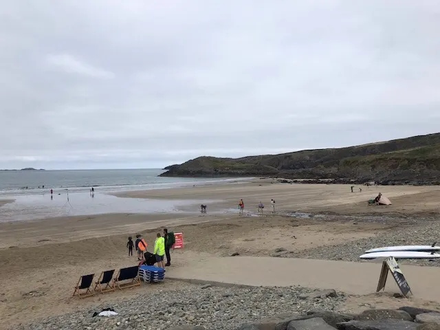 A nice beach\cove where people were setting up for the day. People were already surfing...