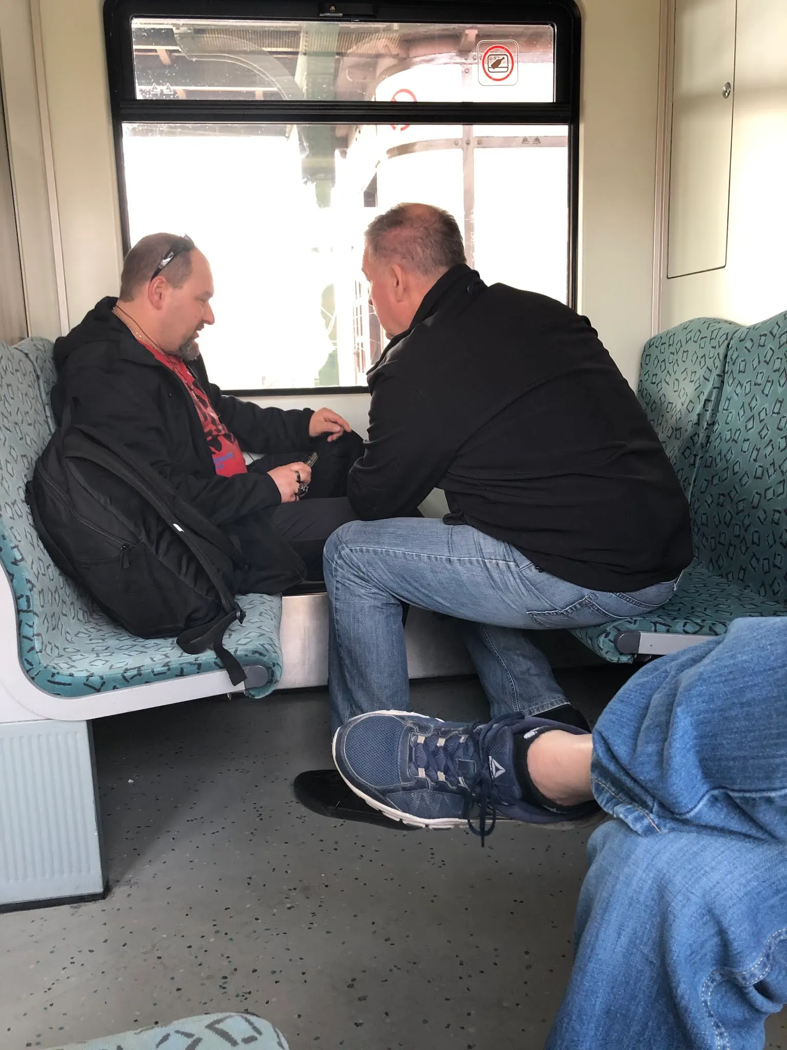 Tim pestering a passenger on the train to validate we were not going to Moscow, fussing