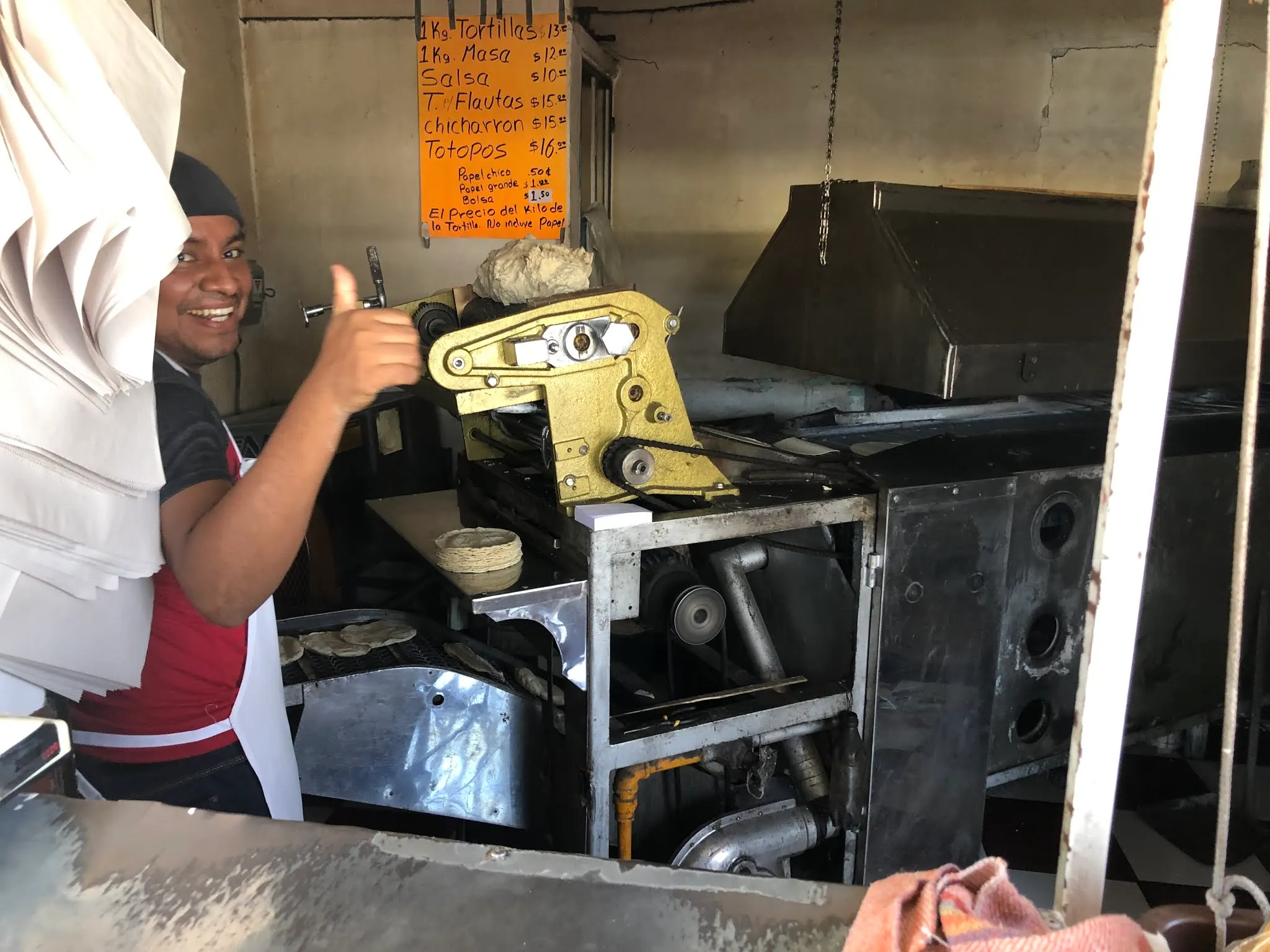 This guy was working in a very hot shop making tortillas that he sold by the kilogram. At first he did not want his picture taken. I talked him into it. See his smile!!!