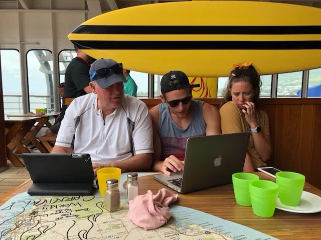 The group looking at pictures and the old guy trying to quickly blog.....