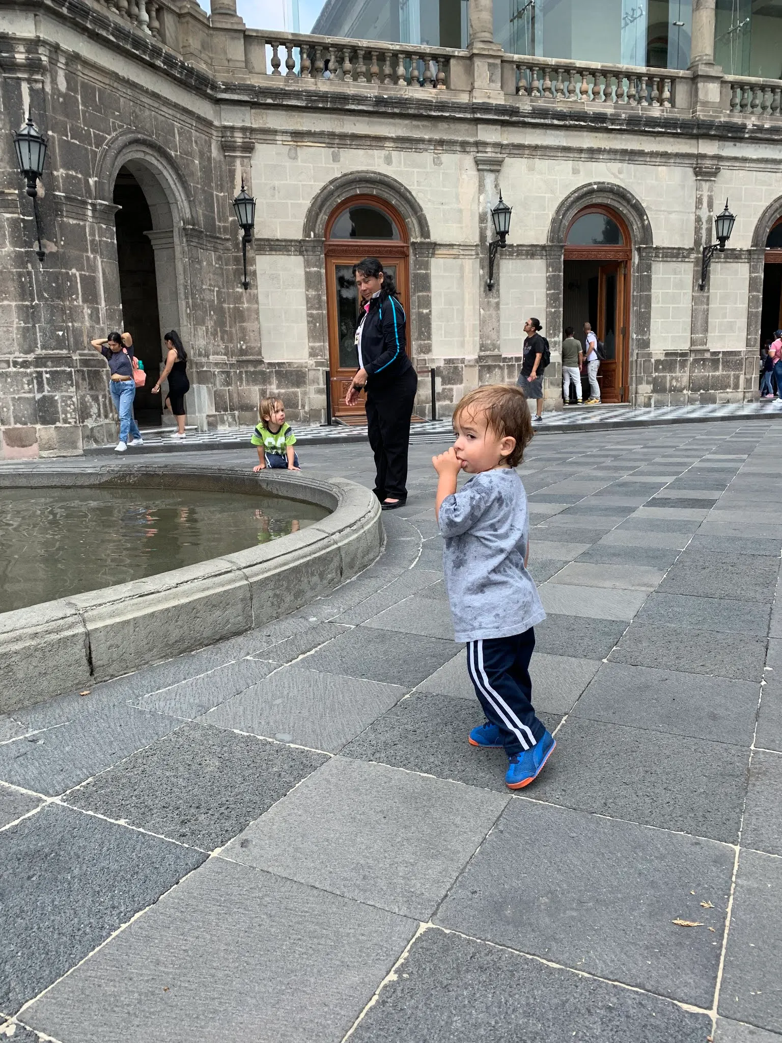 Atticus with Blanca and Lorenzo in the background playing in a fountain at the Castle.