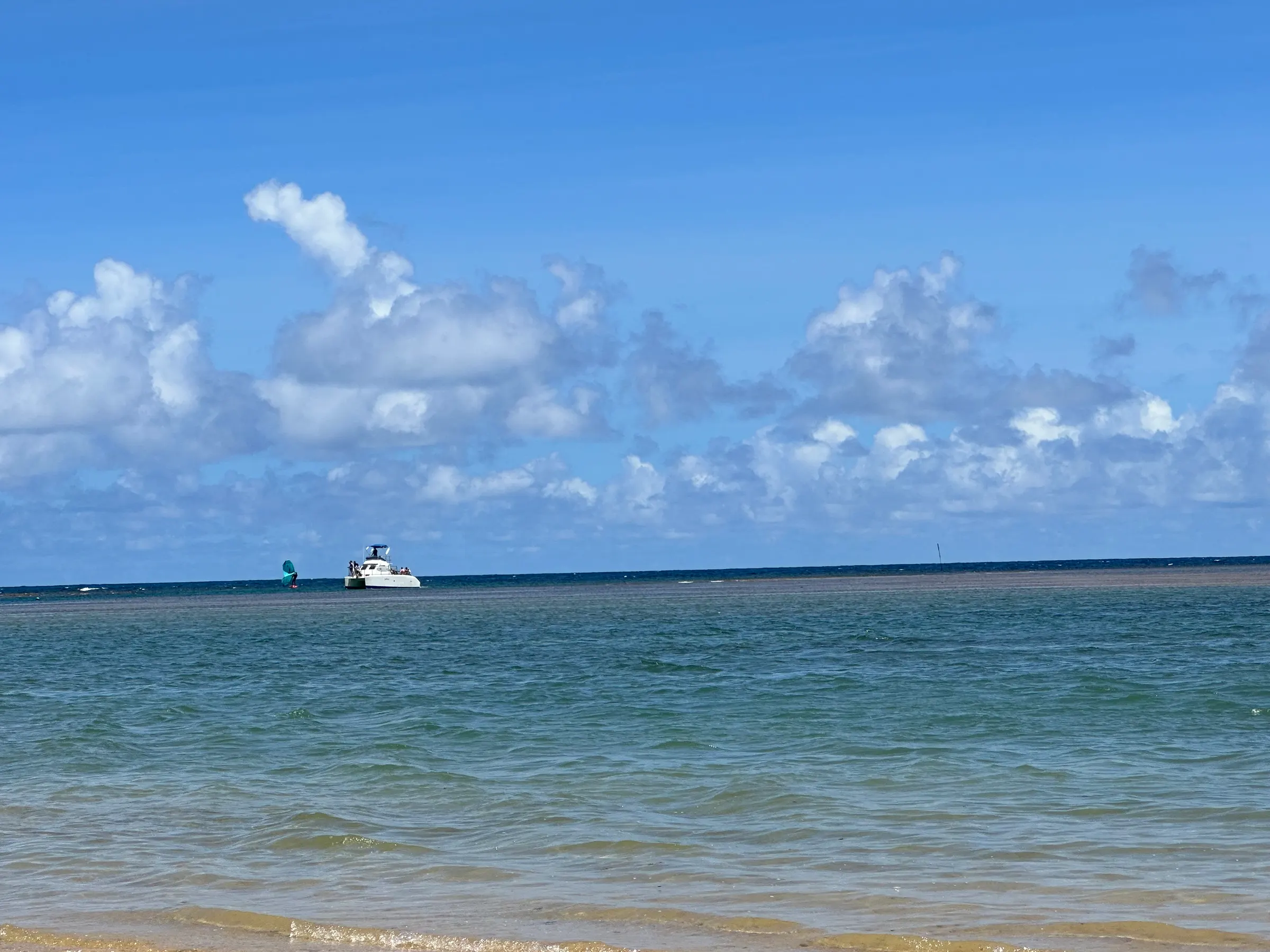 A boat coming into the small, sandy, marina.