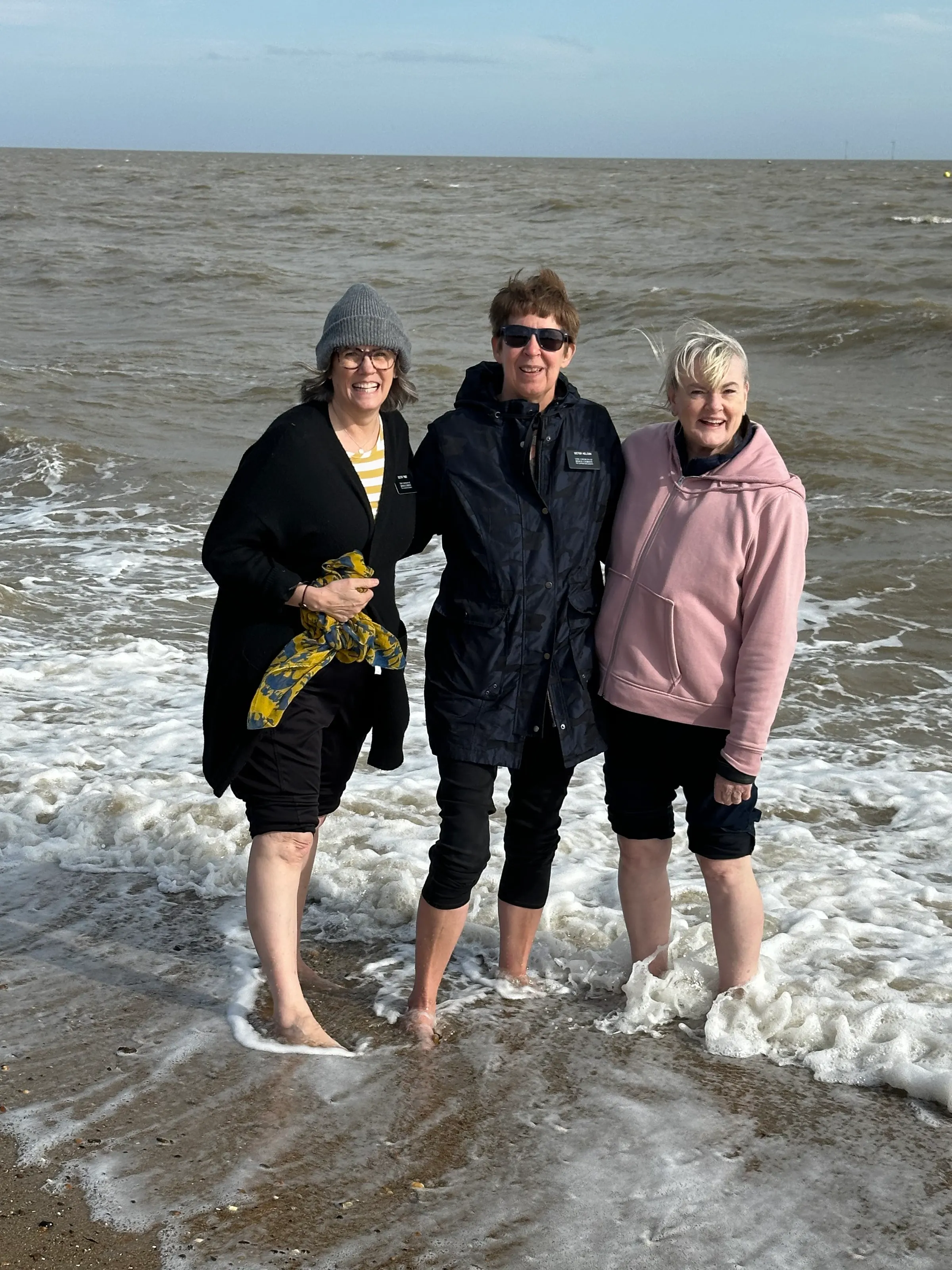 Enjoying the ‘warm’ water. Denise, Carol and Kathy in the wind at the sea shore.